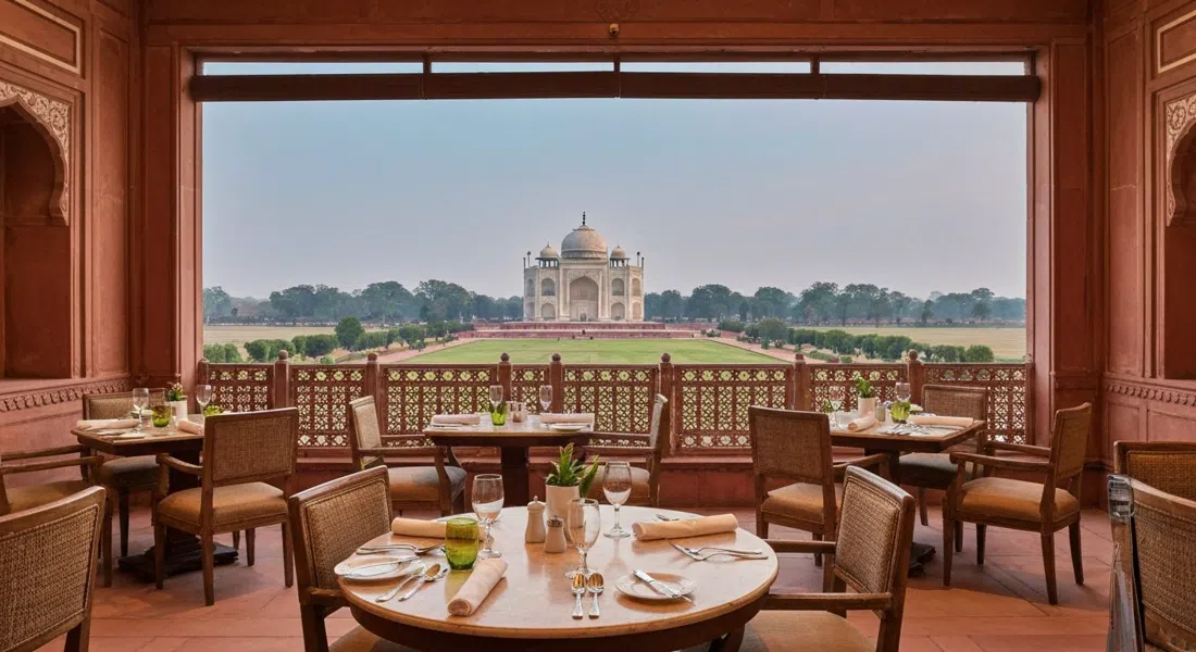 el comedor de alta cocina en Esphahan dentro de The Oberoi Amarvilas, mesas iluminadas con velas, vajilla formal y ambiente con vistas al Taj al atardecer